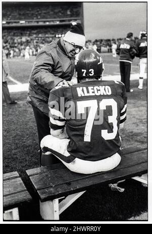 New York Jets équipe médecin et pionnier de la médecine sportive Dr. James Nicholas conseils défensifs s'attaquent à Joe Klecko. Sur le banc pendant un match au Shea Stadium. Vers 1977. Banque D'Images