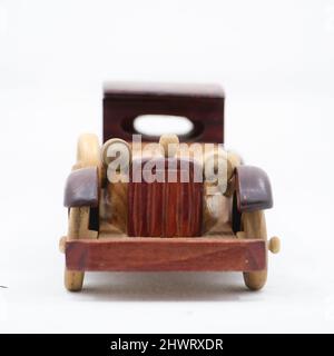 vue avant d'une voiture miniature en bois brun de modèle vintage isolée sur fond blanc Banque D'Images