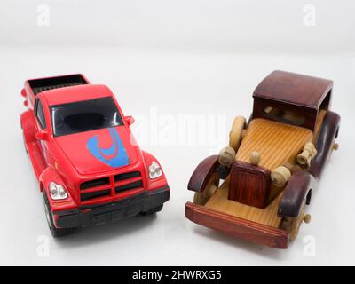 modèles miniatures d'un camion de remorquage rouge et d'une voiture vintage en bois marron isolés sur fond blanc Banque D'Images