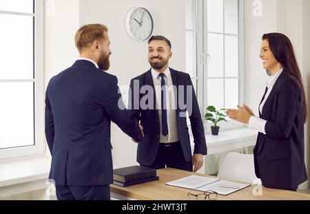 Un client heureux se serrer la main avec un conseiller d'affaires ou un avocat dans le bureau ou la salle d'audience Banque D'Images