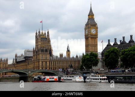 Chambres du Parlement, Londres avec une partie du pont de Westminster et des bateaux de plaisance touristiques amarrés dans des conditions météorologiques typiquement couvert Banque D'Images