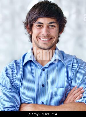 Rempli de positivité. Un beau jeune homme debout avec ses bras pliés. Banque D'Images