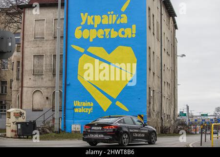 Gdansk, Pologne. , . Cœur jaune percé de balles sur fond bleu avec inscription sur ukrainien et polonais - l'Ukraine est en train de se battre - est vu à Gdansk, Pologne le 6 mars 2022 la fresque a été créée pour soutenir le peuple ukrainien pendant la guerre russe contre l'Ukraine. Credit: Vadim Pacajev/Alay Live News Banque D'Images