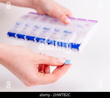 Femmes mains prenant la pilule ou la vitamine de la boîte. Concept de soins de santé et de traitement médical. Photo de haute qualité Banque D'Images