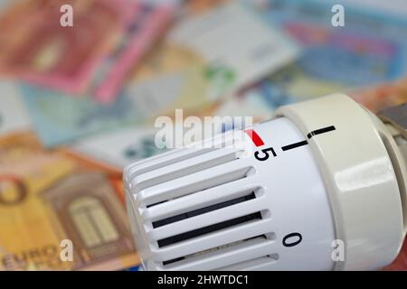 Thermostat devant les billets, symbolique des coûts de chauffage Banque D'Images