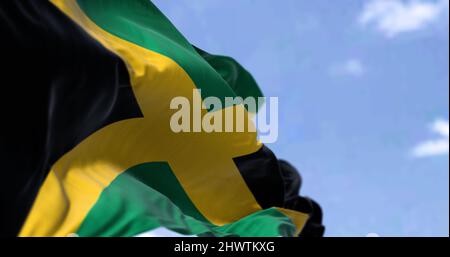 Détail du drapeau national de la Jamaïque agitant dans le vent un jour clair. La Jamaïque est un pays insulaire situé dans la mer des Caraïbes. Mise au point sélective. Banque D'Images