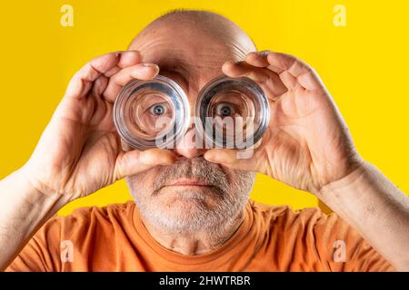 Un homme regardant à travers le fond des lunettes comme des jumelles Banque D'Images