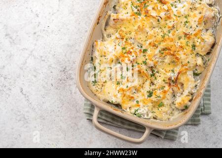 Cocotte de poisson blanc, chou-fleur, pomme de terre au fromage, crème sure et oignon Banque D'Images