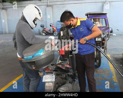 Caloocan, Philippines. 7th mars 2022. Un pilote de moto regarde sa moto en plein ravitaillement.les Philippines connaissent des prix élevés du pétrole et d'autres carburants dans le conflit entre la Russie et l'Ukraine. Le ministère de l'énergie avertit le public de se préparer à une augmentation du coût du carburant dans les jours à venir, et il a déclaré que cette répercussion sur les prix se produit non seulement aux Philippines, mais aussi dans d'autres parties du monde. Le Gouvernement philippin prépare un plan d'urgence pour subventionner les coûts du carburant pour le secteur des transports publics, les agriculteurs et les pêcheurs. (Image de crédit : © Josefiel Rive Banque D'Images