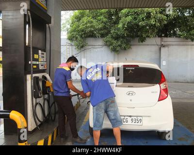 Caloocan, Philippines. 7th mars 2022. Le préposé à l'essence ravitaillant une voiture.les Philippines connaissent une flambée des prix du pétrole et d'autres produits combustibles dans le conflit entre la Russie et l'Ukraine. Le ministère de l'énergie avertit le public de se préparer à une augmentation du coût du carburant dans les jours à venir, et il a déclaré que cette répercussion sur les prix se produit non seulement aux Philippines, mais aussi dans d'autres parties du monde. Le Gouvernement philippin prépare un plan d'urgence pour subventionner les coûts du carburant pour le secteur des transports publics, les agriculteurs et les pêcheurs. (Credit image: © Josefiel Rivera/SOPA Images via ZUMA P Banque D'Images