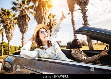 Un jeune couple heureux qui profite de vacances d'été en voiture convertible Banque D'Images