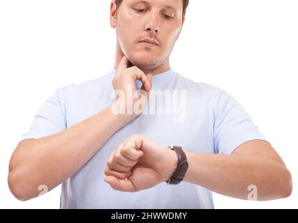 S'assurer que ses battements de cœur sont réguliers. Jeune homme prenant son rythme cardiaque sur fond blanc. Banque D'Images