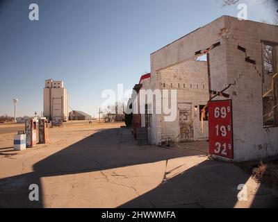 Station-service abandonnée le long de la route 66 dans la ville d'Adrian, dans l'ouest du Texas. Le bâtiment se détériore lentement. Les anciennes pompes à gaz et l'affiche montrent de l'usure. Banque D'Images