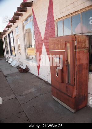 Station-service abandonnée le long de la route 66 dans la ville d'Adrian, dans l'ouest du Texas. Le bâtiment se détériore lentement. Les anciennes pompes à gaz et l'affiche montrent de l'usure. Banque D'Images