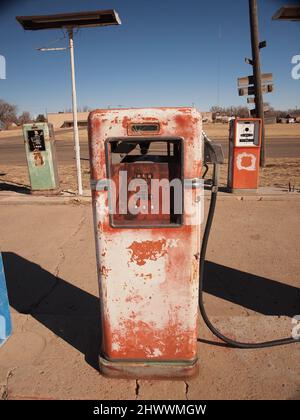 Station-service abandonnée le long de la route 66 dans la ville d'Adrian, dans l'ouest du Texas. Le bâtiment se détériore lentement. Les anciennes pompes à gaz et l'affiche montrent de l'usure. Banque D'Images