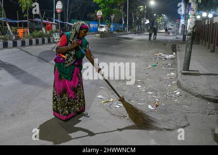 Dhaka, Bangladesh. 08th mars 2022. Halima, un ouvrier de nettoyage de la corporation de ville, est vu balayer les rues la nuit dans la capitale Dhaka. Crédit : SOPA Images Limited/Alamy Live News Banque D'Images