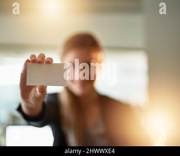 Ici, prenez mon numéro. Photo d'une jeune femme d'affaires tenant une carte de visite vierge au bureau. Banque D'Images