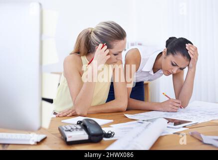 Ce nouveau design les a fait tomber. Deux jeunes femmes architectes travaillant sur de nouvelles conceptions. Banque D'Images