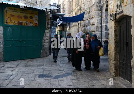 Des femmes palestiniennes marchent près des gardes frontière israéliens dans la rue Al-Wad, dans le quartier musulman de la vieille ville de Jérusalem. Banque D'Images