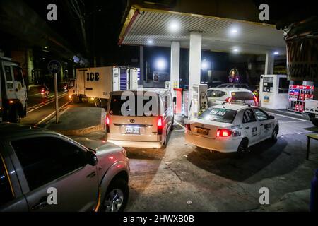 Quezon, Philippines. 7th mars 2022. Les conducteurs font la queue pour faire le plein de leurs véhicules à minuit dans la ville de Quezon, aux Philippines, le 7 mars 2022. Mardi, les compagnies pétrolières ont imposé une nouvelle série de hausses de carburant dans le pays d'Asie du Sud-est. Crédit: Rouelle Umali/Xinhua/Alamy Live News Banque D'Images