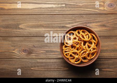 Bretzels dans un bol en céramique sur fond de bois avec espace vide pour le texte. Bretzels à plat, vue de dessus, espace de copie Banque D'Images