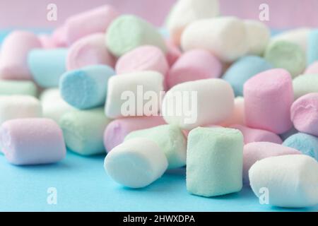 Guimauves colorées sur fond bleu pâle. Banque D'Images