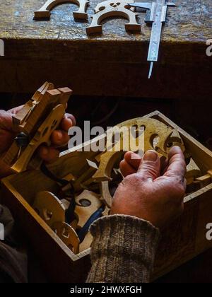 Carlos Roberts maître luthier violon fabricant choosignez le pont droit pour un nouveau violoncelle de sa production à son atelier Banque D'Images