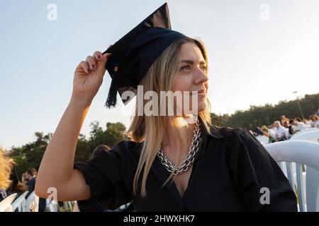 Étudiant gradué debout avec Cap. La jeune fille est diplômée de l'université et elle est si heureuse et fière. Licence. Réussite scolaire. Banque D'Images