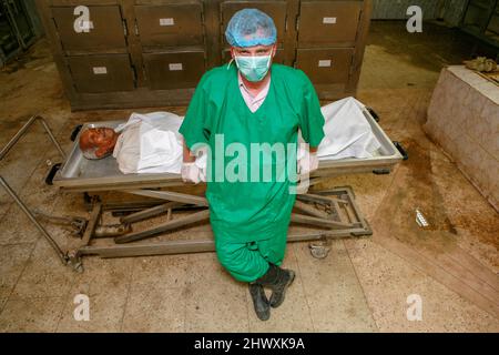 Un pathologiste se tient au-dessus d'un cadavre dans une morgue (MODÈLE RELÂCHÉ) Banque D'Images