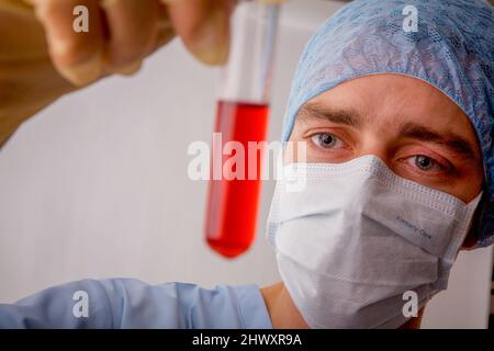 Technicien de laboratoire examinant le contenu liquide d'un tube à essai.(MODÈLE RELÂCHÉ) Banque D'Images