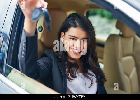 Les clés de la liberté et de l'accessibilité. Photo d'une jeune femme attirante excitée par sa nouvelle voiture. Banque D'Images