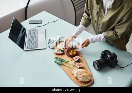 Vue en grand angle chez une photographe culinaire qui organise un plat gastronomique avec des accessoires tout en travaillant en studio, dans un espace de copie Banque D'Images