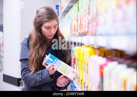 Tilburg, pays-Bas., jeune femme adulte visitant le supermarkt local acheter et acheter de la nourriture et des provisions pour un style de vie sain. Banque D'Images