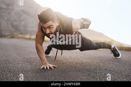 Endurez tous les défis et cela va vous changer. Photo d'un jeune homme sportif qui fait des poussettes tout en s'exerçant à l'extérieur. Banque D'Images