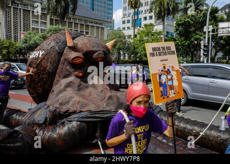 Jakarta, Indonésie. 08th mars 2022. Une militante tient un écriteau tout en tirant une sculpture représentant un poulpe sur le thème de l'oligarchie lors de la manifestation de la Journée internationale de la femme.les militantes se rassemblent à l'occasion de la Journée internationale de la femme dans la région de Monas, à Jakarta. La masse demande au gouvernement de mettre en œuvre un système de protection sociale qui ne fait pas de discrimination à l'égard des femmes. Crédit : SOPA Images Limited/Alamy Live News Banque D'Images