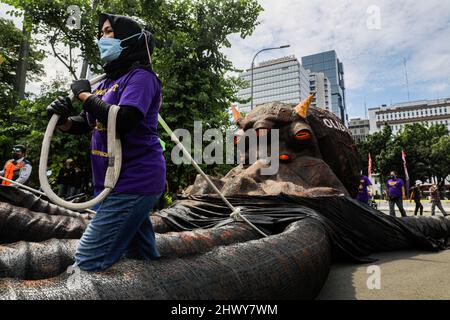 Jakarta, Indonésie. 08th mars 2022. Une militante a vu tirer une sculpture représentant un poulpe sur le thème de l'oligarchie lors de la manifestation de la Journée internationale de la femme.les militantes se rassemblent à l'occasion de la Journée internationale de la femme dans la région de Monas, à Jakarta. La masse demande au gouvernement de mettre en œuvre un système de protection sociale qui ne fait pas de discrimination à l'égard des femmes. Crédit : SOPA Images Limited/Alamy Live News Banque D'Images