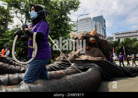 Jakarta, Indonésie. 08th mars 2022. Une militante a vu tirer une sculpture représentant un poulpe sur le thème de l'oligarchie lors de la manifestation de la Journée internationale de la femme.les militantes se rassemblent à l'occasion de la Journée internationale de la femme dans la région de Monas, à Jakarta. La masse demande au gouvernement de mettre en œuvre un système de protection sociale qui ne fait pas de discrimination à l'égard des femmes. (Photo par Aslam Iqbal/SOPA Images/Sipa USA) crédit: SIPA USA/Alay Live News Banque D'Images