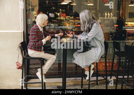 Deux femmes heureuses prenant un café au café Banque D'Images