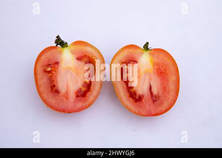 Deux tranches de tomates rouges mûres sur fond blanc Banque D'Images