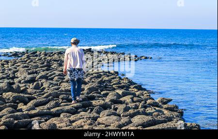 Une touriste qui marche sur la chaussée du géant à l'île Saint-Martin, au Bangladesh. Lever de soleil magique, nuages et vagues sur la côte. Chaussée de Giant. Banque D'Images