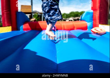 Attention sélective sur le bord avant-propos d'une maison rebondissante avec des enfants flous jouant en arrière-plan Banque D'Images