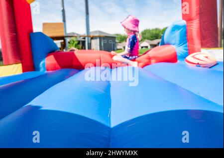 Attention sélective sur le bord avant-propos d'une maison rebondissante avec des enfants flous jouant en arrière-plan Banque D'Images