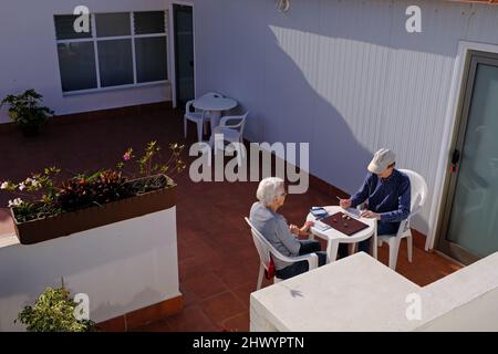 Deux personnes plus âgées jouent à un jeu de dés dans un hôtel. Banque D'Images