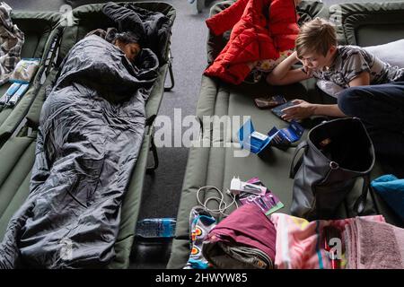 Cracovie, Pologne. 08th mars 2022. Une femme et un garçon ont été vus allongé sur les lits de camp dans la salle des sports du club de Cracovie où un hébergement a été organisé pour les réfugiés d'Ukraine venant de Cracovie. Crédit : SOPA Images Limited/Alamy Live News Banque D'Images