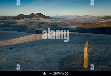 Vue sur la rivière Tweed et les collines d'Eildon depuis le dessus de Scott's View avec une pierre debout qui attrape la lumière du soleil levant un matin gelé. Banque D'Images