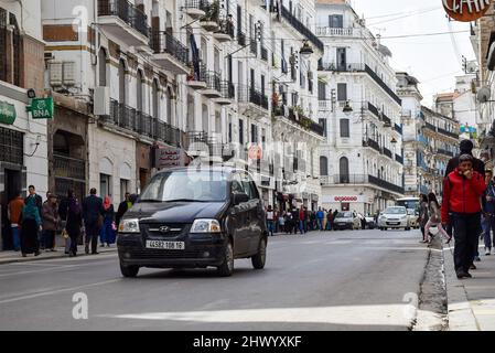 Foule de personnes marchant dans la rue Didouche Mourad dans le centre-ville d'Alger. Les voitures sont dans l'embouteillage. Banque D'Images