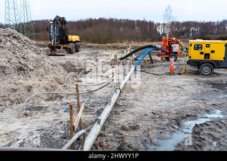 Installation Wellpoint pour se débarrasser des eaux souterraines élevées, des tuyaux en métal et en plastique visibles et d'une grande pompe à eau. Banque D'Images