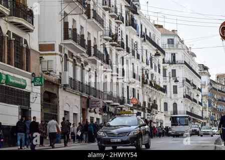 Foule de personnes marchant dans la rue Didouche Mourad dans le centre-ville d'Alger. Les voitures sont dans l'embouteillage. Banque D'Images