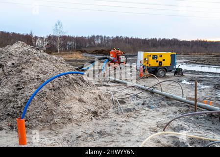 Installation Wellpoint pour se débarrasser des eaux souterraines élevées, des tuyaux en métal et en plastique visibles et d'une grande pompe à eau. Banque D'Images