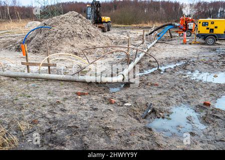 Installation Wellpoint pour se débarrasser des eaux souterraines élevées, des tuyaux en métal et en plastique visibles et d'une grande pompe à eau. Banque D'Images